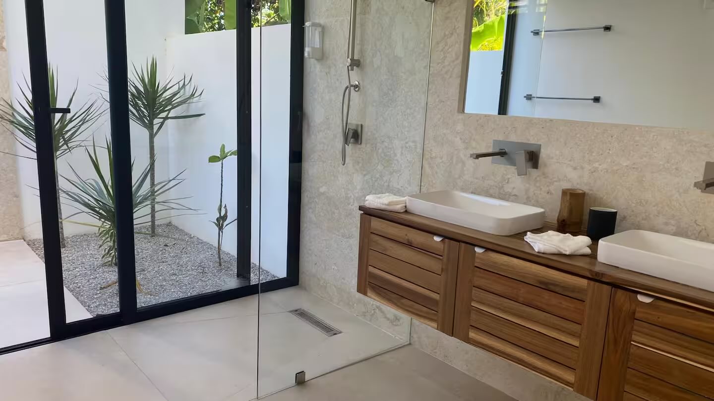 Villa Anick, bathroom with double sink, shower opening onto a planted patio