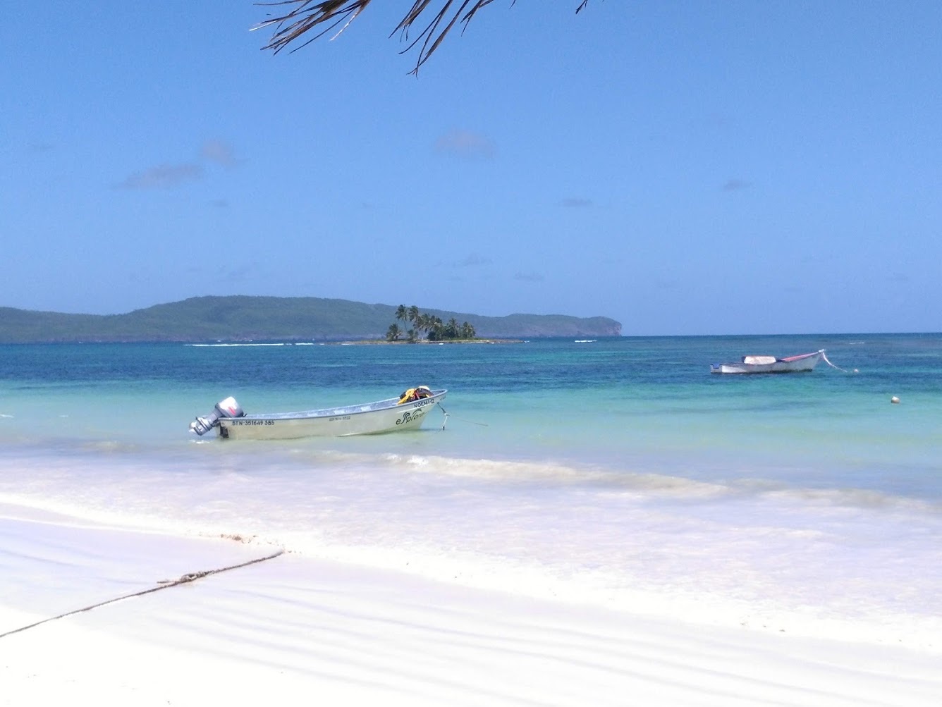 Playa de arena blanca y botes de pescadores sobre un agua turquesa, en Las Galeras