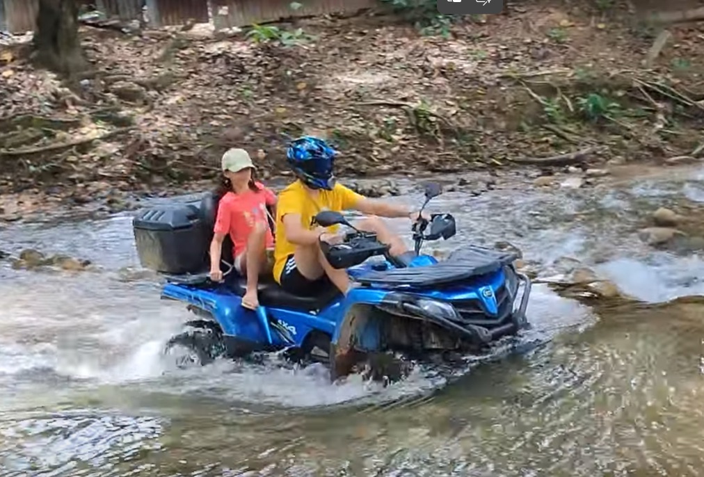 Dos personas en cuatrimoto cruzan un río